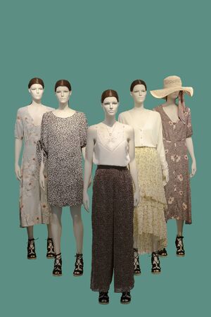 Group of female mannequins wear fashionable summer clothes, isolated on green background. No brand names or copyright objects.の写真素材