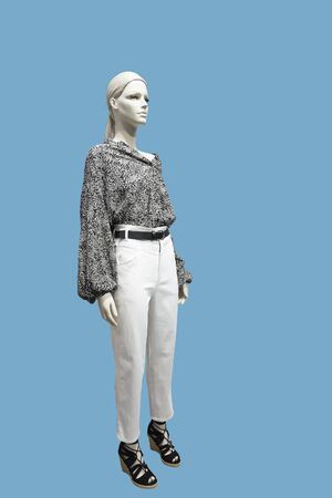 Full-length female mannequin dressed in fashionable clothes, isolated on blue background. No brand names or copyright objects.の写真素材