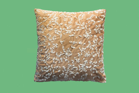 Decorative cushion with floral embroidered pattern. Isolated on green background.の写真素材