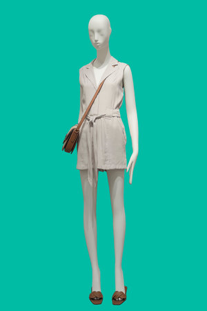 Full length female mannequin dressed in fashionable summer clothes, isolated on green background. No...