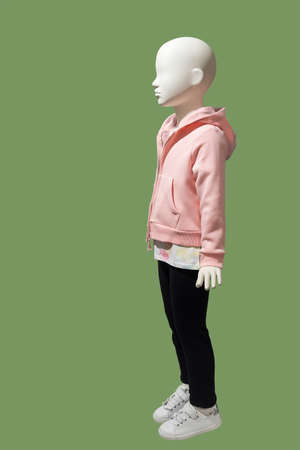 Full length child mannequin dressed in fashionable clothes, isolated on green background. No brand names or copyright objects.の写真素材