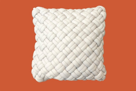 White pillow with braided pillow cover isolated on an orange background
