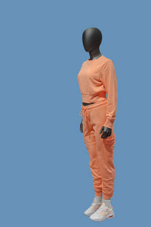 Full length image of a female display mannequin wearing sports suit isolated on a blue background.の写真素材