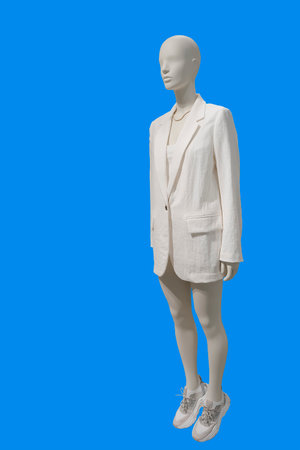 Full length image of a female display mannequin wearing fashionable clothes isolated on a blue backgroundの写真素材