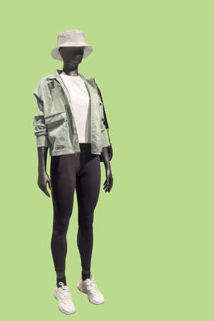 Full length image of a running female display mannequin wearing sportswear isolated on a green backgroundの写真素材