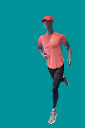 Running image of a male display mannequins wearing sportswear isolated on a blue backgroundの写真素材