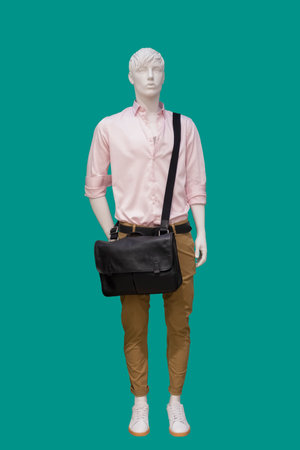 Full length image of a male display mannequin wearing fashionable clothes isolated on a green backgroundの写真素材