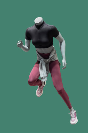 Full length image of a female display mannequin dressed in sportswear isolated on a green backgroundの写真素材