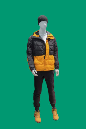 Full length male mannequin dressed in warm padded jacket, isolated on a green background