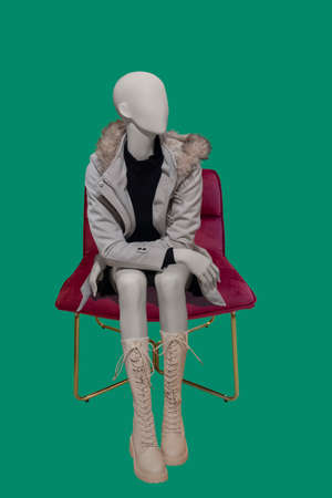 Sitting image of a female display mannequin wearing blue knitted dress isolated on a white backgroundの写真素材