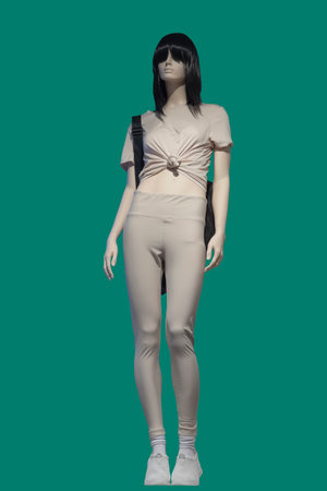 Full length image of a female display mannequin wearing fashionable sportswear isolated on green backgroundの写真素材