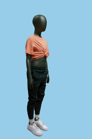 Full length image of a child display mannequin wearing fashionable sportswear isolated on blue backgroundの写真素材