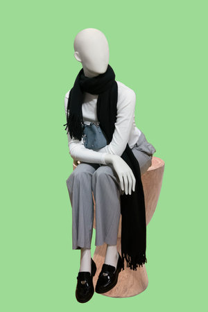 Full length image of a female display sitting mannequin isolated on green backgroundの写真素材