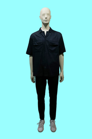 Full length image of a male display mannequin wearing a shirt, trousers and sneakers, isolated on green backgroundの写真素材