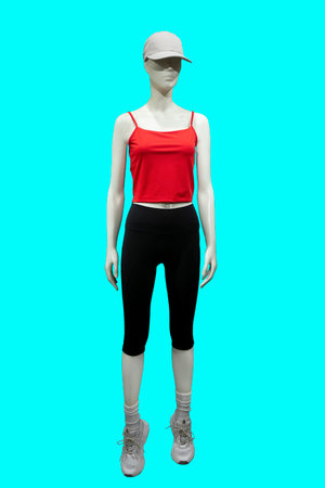 Full length image of a female display mannequin wearing red sleeveless top and short tight pants isolated on blue backgroundの写真素材