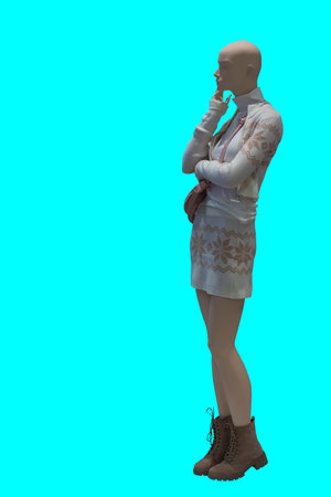 Full length image of a female display mannequin wearing knitted suit with skirt and cardigan isolated on blue backgroundの写真素材