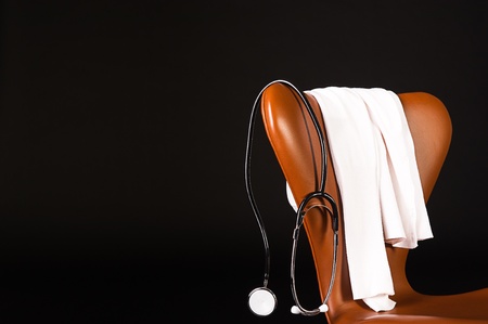 A doctors stethoscope hanging over a chair.の写真素材
