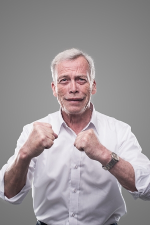 Smiling senior holding his fists up and are readyの写真素材