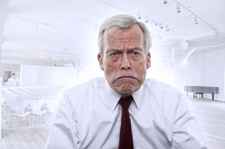Upset depressed Caucasian businessman with huge frown and mouth curved down at corners, portraitの写真素材