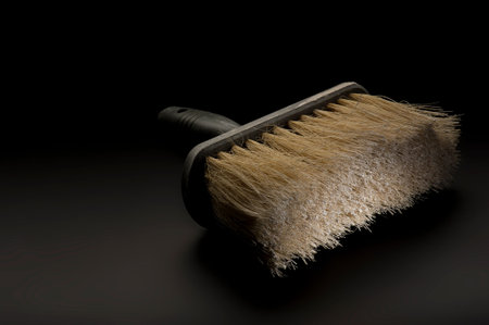 Close up view of a new clean large paintbrush or wallpapering brush lying on a dark background...