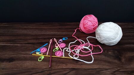 Pink and white yarn balls with crocheting accessories.の写真素材