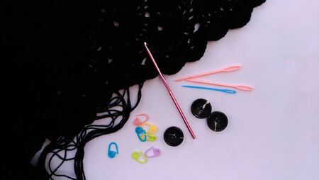 black crocheted scarf with crocheting accessories on white background.top view,close up shotの写真素材