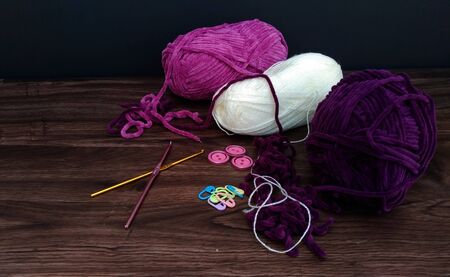 colorful yarn balls with crocheting accessories on wooden background.close up shotの写真素材