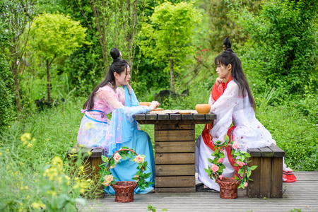 Chinese girls with traditional costume playing chinese board gameのeditorial素材