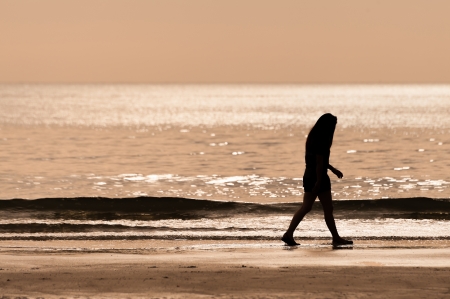 sillhouette woman walking on the beachの写真素材