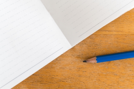 paper of old booklet and pencil on wood tableの写真素材