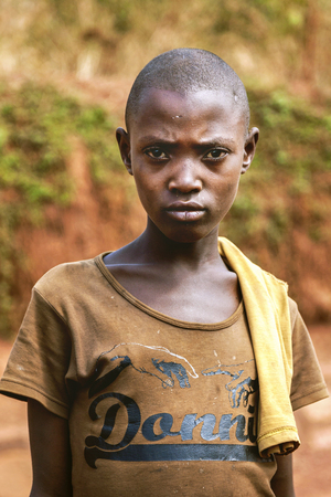 Kibuye, Rwanda, Africa - September 11, 2015:  Unknown girl. The young girl is looking with a face that is angry and nervous. She has short hair and male image and her old clothes reveal her poverty.のeditorial素材