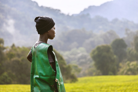 Kigali, Rwanda, Africa - September 7, 2015: Unidentified girl. The African young girl. She wears worker's clothing and a beanie on her head. She watches tea plantations and mountains across her.のeditorial素材