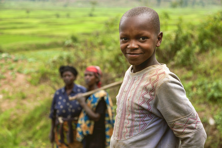 Ruhengeri, Rwanda - September 9, 2015: Unidentified women and child. The African worker children working too early ages in rice paddy. They start to work early morning with their families.のeditorial素材