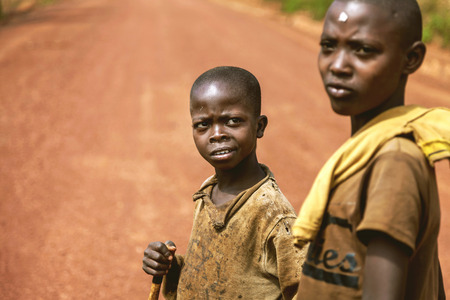 Kibuye, Rwanda, Africa - September 11, 2015:  Unknown children. Two little African boys on red land. Their old clothes reveal their poverty but the children do not mind it.のeditorial素材