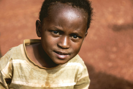 Kibuye, Rwanda, Africa - September 11, 2015: Unknown child. The little African boy. Despite his/her old clothes on him, he is smiling with his eyes being full of hope.のeditorial素材