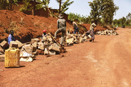 Kibuye, Rwanda - September 11, 2015:  Unidentified workers. Red earth land and the African workers. They work under the sun and they look into lens curiously.のeditorial素材