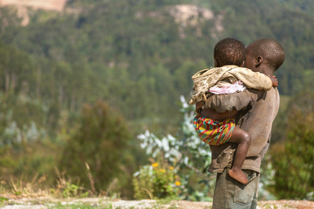 Ruhengeri, Rwanda, Africa - September 9, 2015: Unidentified children. The boy who looks into the rainforests from their village with his/her little brother/sister that he embraces.のeditorial素材