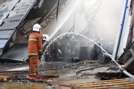 NILAI, MALAYSIA - 12 APRIL 2021: Malaysian firefighters try to put out a large fire that destroyed a...