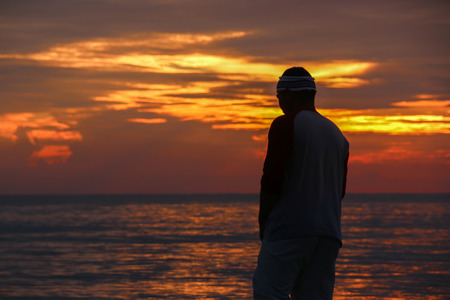 Young man is looking at the sunrise.の写真素材