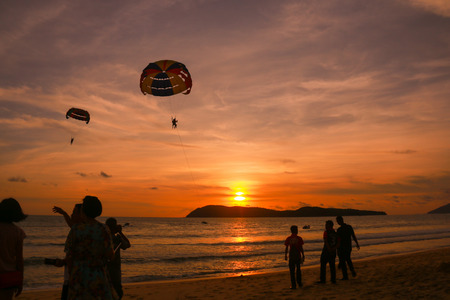 silhouette of parachute and people at the beachの写真素材