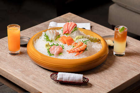 Japanese cuisine. Sashimi with salmon, shrimp and prawns on a wooden board.の写真素材