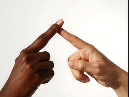 A close-up shot of two hands with contrasting skin tones, their index fingers gently touching, symbolizing connection and unity.の素材