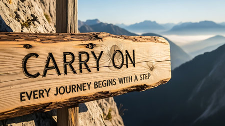 Inspirational wooden sign reading 'CARRY ON Every Journey Begins With A Step' mounted on post in foggy mountain range, symbolizing perseverance and adventure in nature.の素材