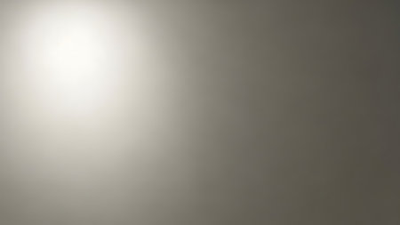 Elegant soft light gradient seamlessly fading into a dark backdrop, featuring delicate texture and smooth tonal transitions ideal for backgrounds and overlays.の素材