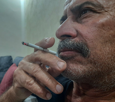 an elderly person is smoking while watching T.Vのeditorial素材