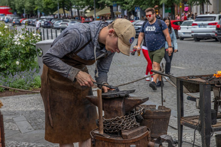 A young man is doing metal handcrafts in lively and lovely Prague city during afternoon.