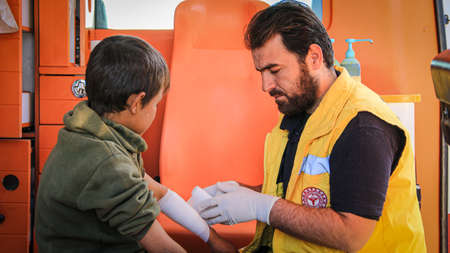 nurse embraces a child and treating him inside the ambulance.
Aleppo, Syria 12 Desember 2020のeditorial素材