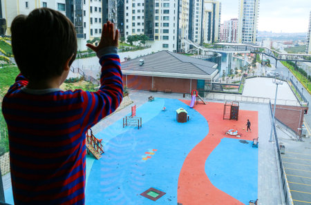 A child looks out at the garden from the balcony.