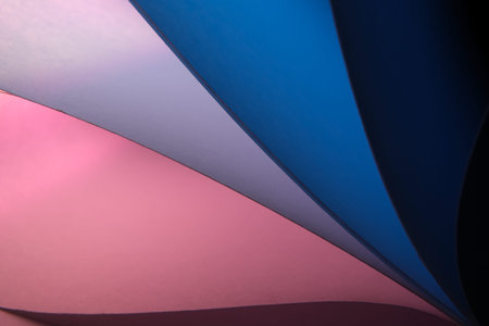 Abstract background made of colorful curved sheets of paper on a dark background