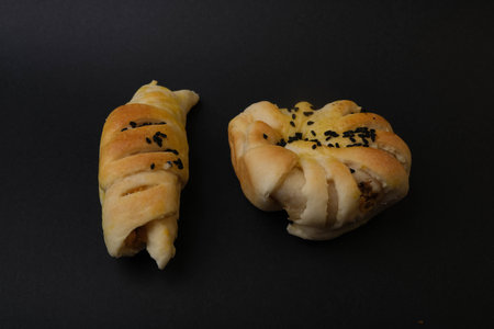 Buns with sesame seeds on a black background, top view